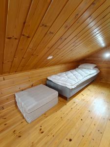 a bed in a room with a wooden ceiling at Honkaranta Cottage in Jämsä