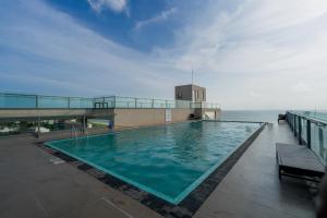 a swimming pool on top of a building next to the ocean at Ceylon Vacation - Negombo in Negombo