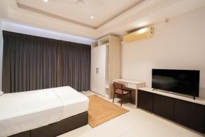 a hotel room with a bed and a flat screen tv at Ceylon Vacation - Negombo in Negombo