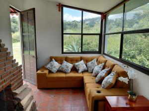 a living room with a couch and windows at Finca Itaca in San Esteban Tizatlán