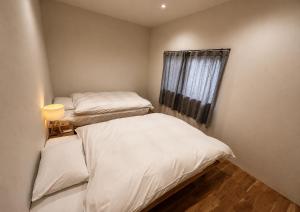 two beds in a small room with a window at 四方宿 in Hokuto