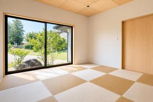 an empty room with a large window and a door at 四方宿 in Hokuto