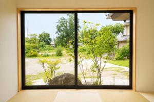 a window with a view of a yard at 四方宿 in Hokuto +22 photos