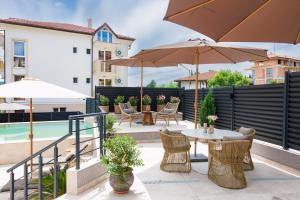 a patio with tables and chairs and umbrellas at Limani Vasiliko in Tsarevo