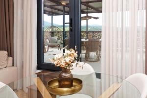 a living room with a glass table with a vase of flowers at Limani Vasiliko in Tsarevo
