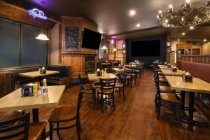 a dining room with tables and chairs in a restaurant at Super 8 by Wyndham Gananoque - Country Squire Resort in Gananoque