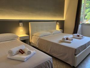 two beds with towels on them in a bedroom at Chill House Reggio Calabria in Reggio di Calabria