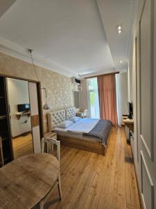 a bedroom with a bed and a table in it at Happy Stay Hotel in Kutaisi