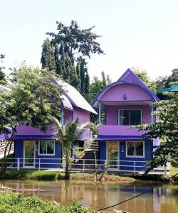 a purple house sitting on top of a flooded street at แพ ณ จันทร์ in Sathani Nam Tok