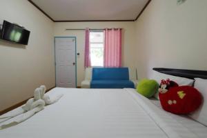 a bedroom with a bed with stuffed animals on it at แพ ณ จันทร์ in Sathani Nam Tok +7 photos
