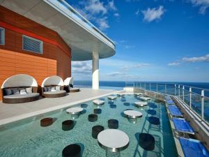a pool on a cruise ship with tables and chairs at Wyndham Goseong Gangwon Hotel in Goseong