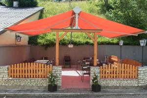 a red canopy over a patio with tables and chairs at Gasthaus Zum Stampf in Strass im Attergau +4 photos