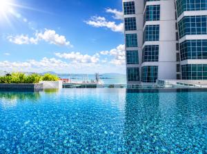 a swimming pool in front of two tall buildings at Luxury Seaview 2BR Suite Near Georgetown Maritime Penang 0706 in George Town