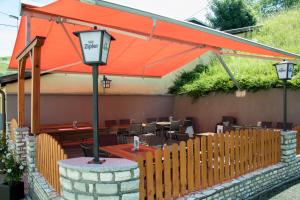 a restaurant with an orange umbrella and tables and chairs at Gasthaus Zum Stampf in Strass im Attergau