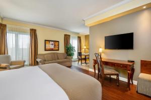 ein Hotelzimmer mit Bett und Schreibtisch in der Unterkunft Hotel Brossard, an Ascend Collection Hotel in Brossard