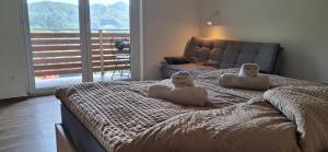 a bedroom with a bed with two stuffed animals on it at Apartmaji Božiček Olimje in Podčetrtek