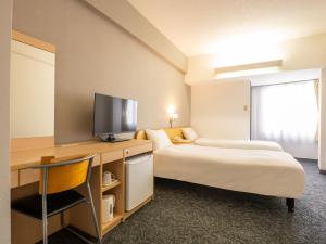 a hotel room with two beds and a television at Chisun Inn Nagoya in Nagoya +58 photos
