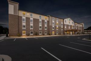 an empty parking lot in front of a large building at WoodSpring Suites Atlanta Canton in Canton