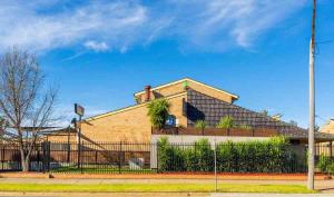 a house with a fence in front of it at Ashmont Inn Hotel in Wagga Wagga