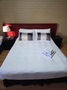 a bed with two towels on top of it at Ashmont Inn Hotel in Wagga Wagga