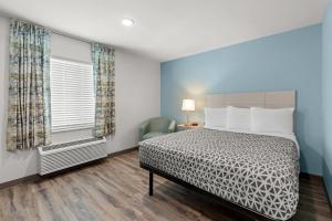 a bedroom with a bed and a window at WoodSpring Suites Atlanta Canton in Canton