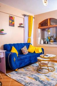 a blue couch in a living room with a table at Aroma homes in Meru