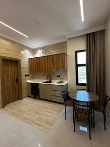 a kitchen with a table and a sink and a table and chairs at بيوت عطلات البيت الريفي للضيافه السياحي in Al Namas