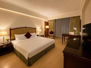 a hotel room with a bed and a flat screen tv at Oriental Crystal Hotel in Kajang +7 photos