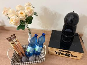 a table with a vase of roses and bottles of water at Chill House Reggio Calabria in Reggio di Calabria
