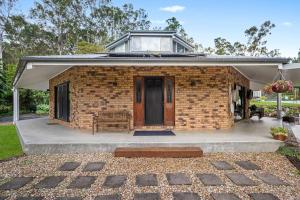 a brick house with a building on top of it at The Hidden Gem in Tamborine Mountain in Tamborine