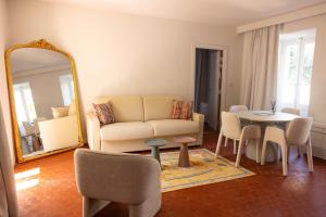 a living room with a couch and a table and a mirror at Hôtel Casa Elena in Erbalunga