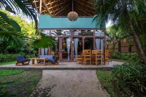 a restaurant with tables and chairs in front of a building at Buko Beach Resort in El Nido