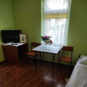 a room with a table with a vase of flowers on it at Hostel Promyk in Iwonicz-Zdrój