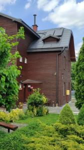 a large wooden building with a black roof at Hostel Promyk in Iwonicz-Zdrój