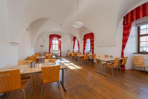 a dining room with tables and chairs and red curtains at Hotel Adalbert in Prague +51 photos