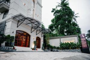 a building with a tree in front of it at Raphilhin The Business Hotel in Perintalmanna