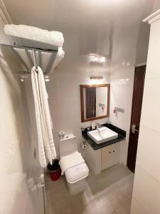 a white bathroom with a toilet and a sink at Nascent Gardenia Residence in Dhaka +21 photos