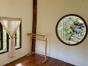 a room with a round window and a mirror at Teepo Ke Hillside Jungle Lodge in Ban Mae Sapok Nua