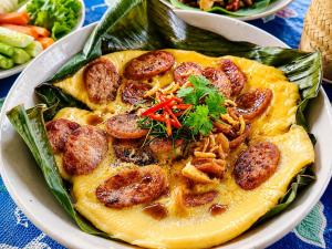 a bowl of food with sausage and peppers on a table at Teepo Ke Hillside Jungle Lodge in Ban Mae Sapok Nua