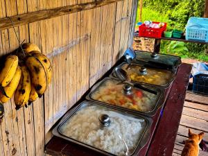 two trays of food on a stove with bananas at Teepo Ke Hillside Jungle Lodge in Ban Mae Sapok Nua +18 photos