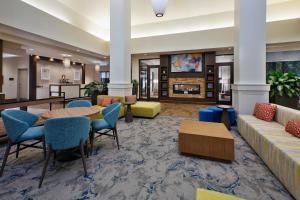 a lobby with a couch and tables and chairs at Hilton Garden Inn Akron in Akron