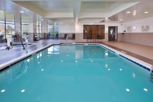 a large swimming pool with blue water in a building at Hilton Garden Inn Akron in Akron