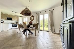 a kitchen and dining room with a table and chairs at Spacious house 300m from the beach in Hermanville-sur-Mer