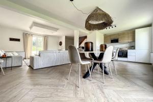 a kitchen and living room with a table and chairs at Spacious house 300m from the beach in Hermanville-sur-Mer