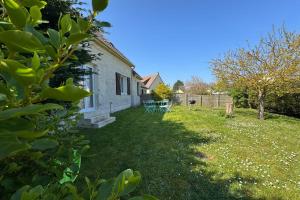 a white house with a yard with a table at Spacious house 300m from the beach in Hermanville-sur-Mer