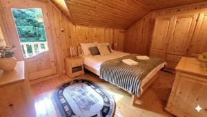 a bedroom with a bed in a wooden cabin at Cabana de la rau Satic in Sătic +21 photos