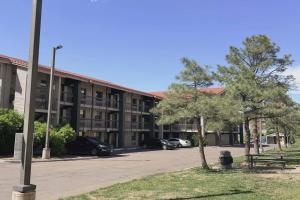 a large building with cars parked in a parking lot at Ramada by Wyndham Westminster Denver in Westminster