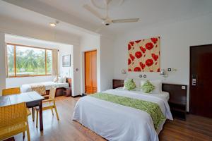 a hotel room with two beds and a table at Gloria Grand Hotel in Unawatuna +51 photos