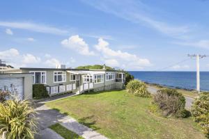 a house with the ocean in the background at Kakanui Ocean Views in Kakanui +3 photos