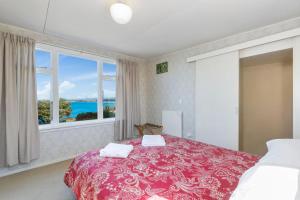 a bedroom with a bed and a large window at Kakanui Ocean Views in Kakanui